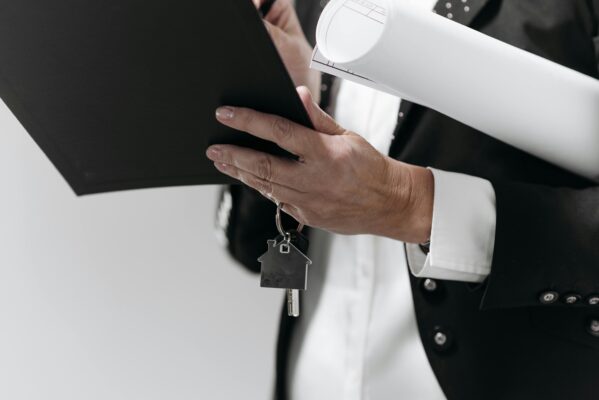 agent holding keys and file board